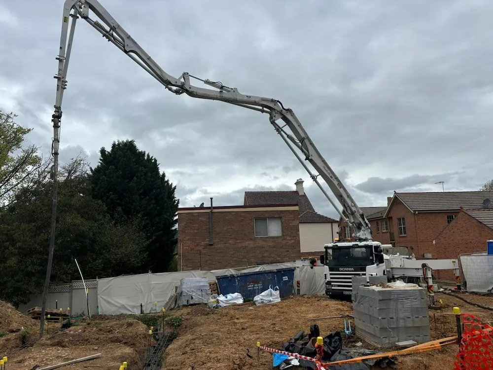 A Concrete Pump is Being Used to Pour Concrete on a Construction Site — Ozi Construction Pty Ltd