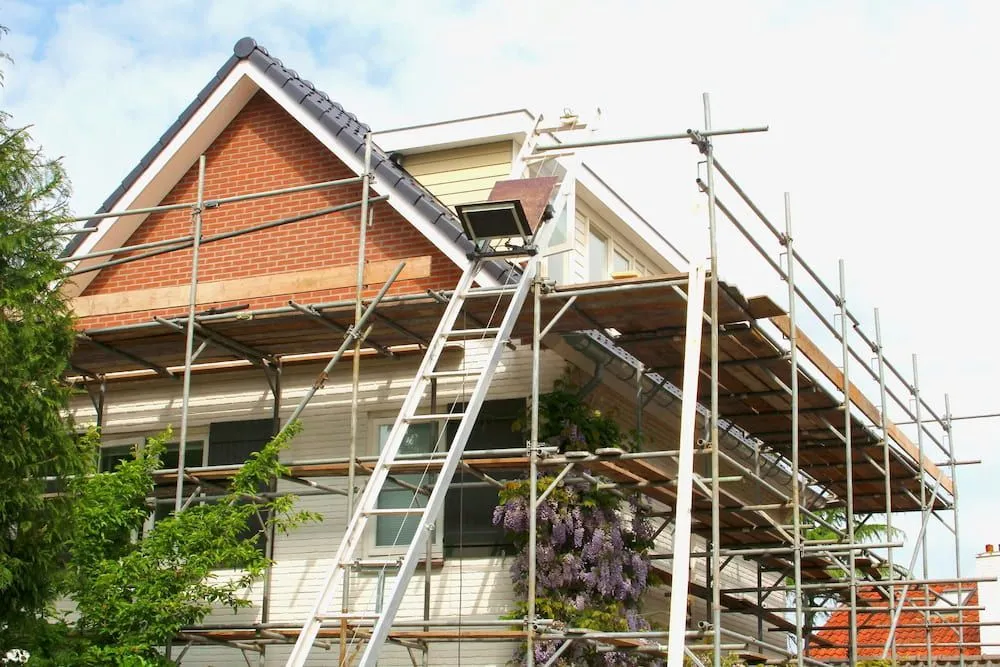 A House is Being Remodeled With Scaffolding and a Ladder — Ozi Construction Pty Ltd in Bondi, NSW