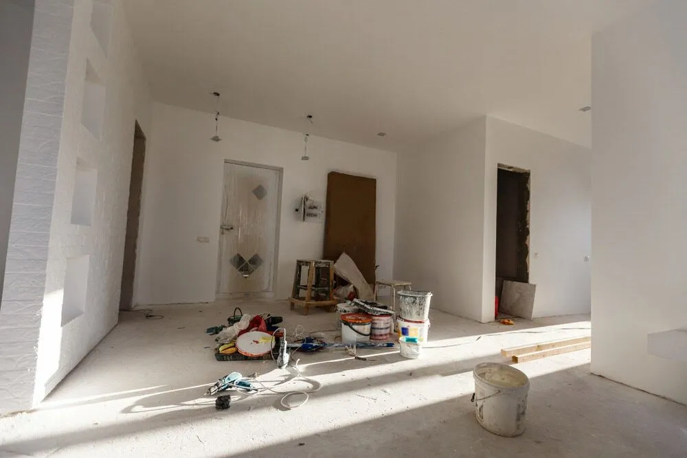 A Room With White Walls and a Bucket of Paint on the Floor — Ozi Construction Pty Ltd in Mosman, NSW
