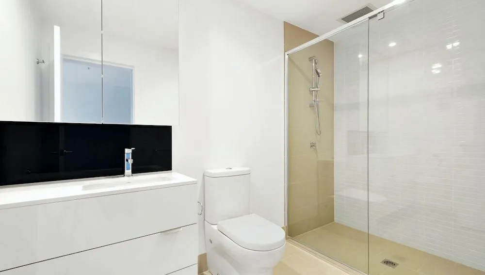 A Bathroom With a Toilet, Sink and Walk in Shower — Ozi Construction Pty Ltd in Mosman, NSW