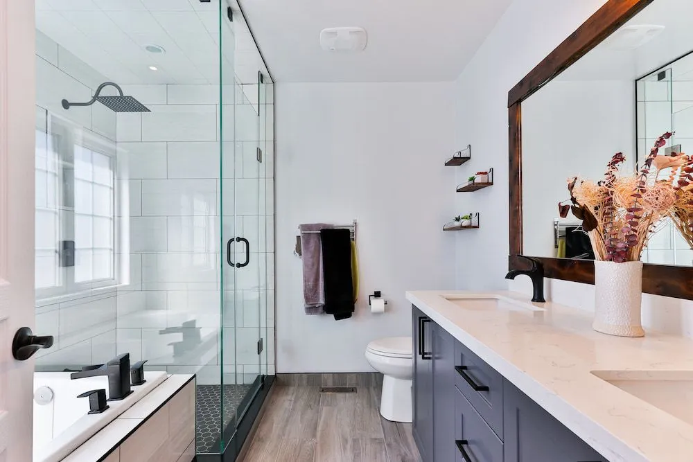A Bathroom With a Walk in Shower, Sink, Toilet and Mirror — Ozi Construction Pty Ltd in North Sydney, NSW