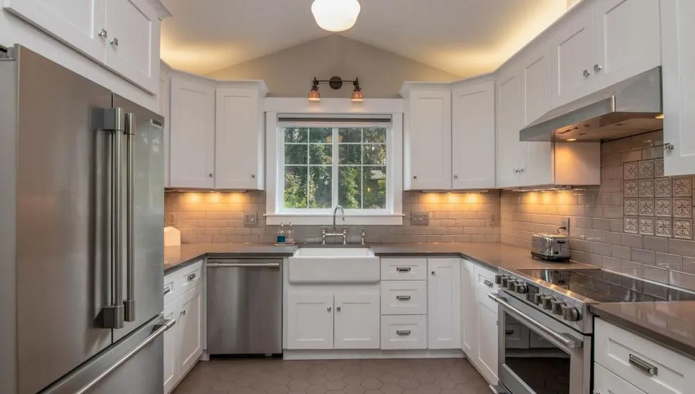 A Kitchen With White Cabinets and Stainless Steel Appliances — Ozi Construction Pty Ltd in Wollongong, NSW